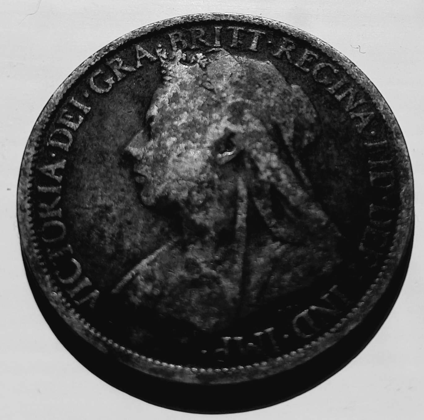 An old penny showing a sideon head with spots from wear.