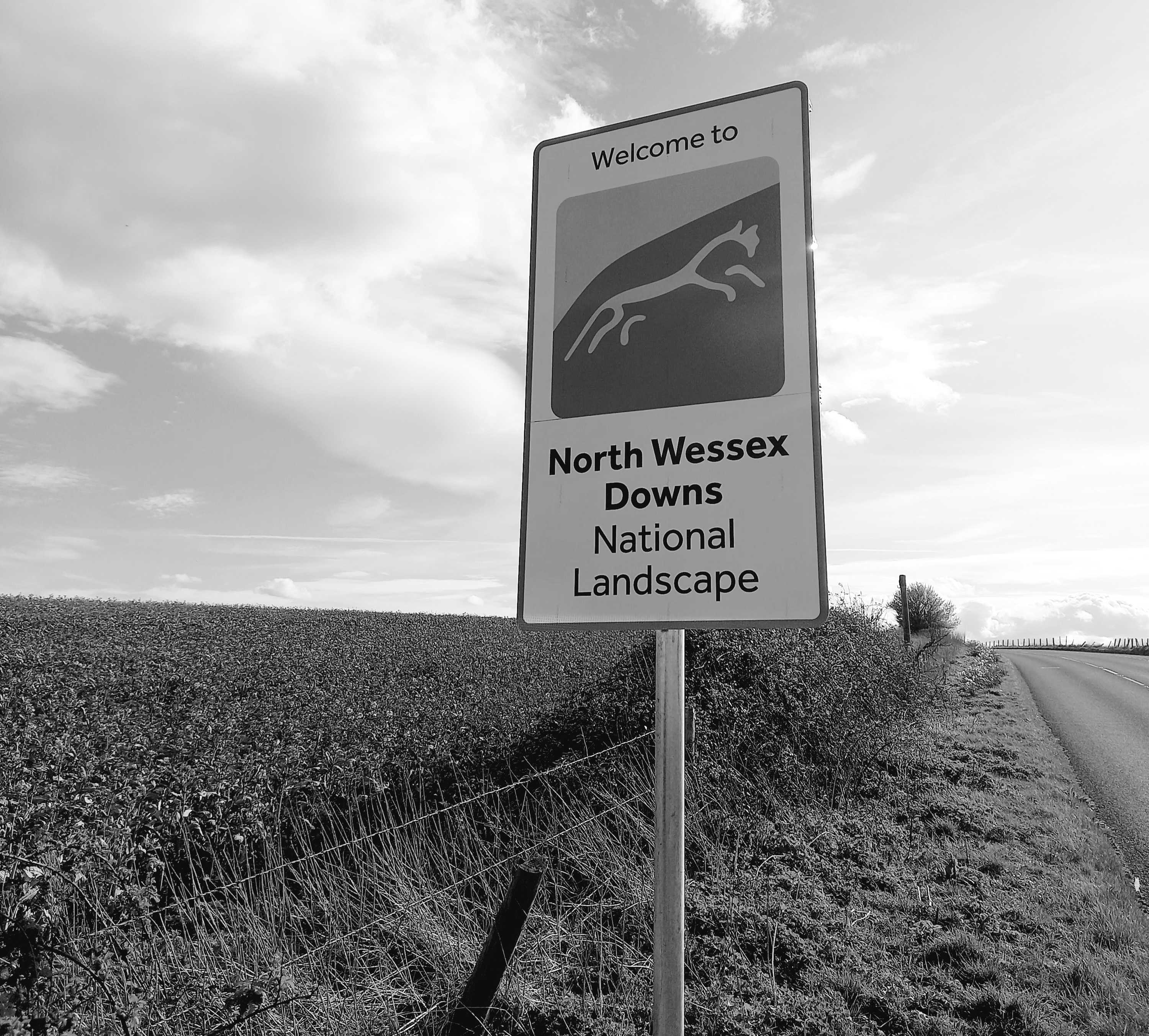 A waymarker that says 'Welcome to North Wessex Downs National Landscape' with a picture of the Uffington White Horse.